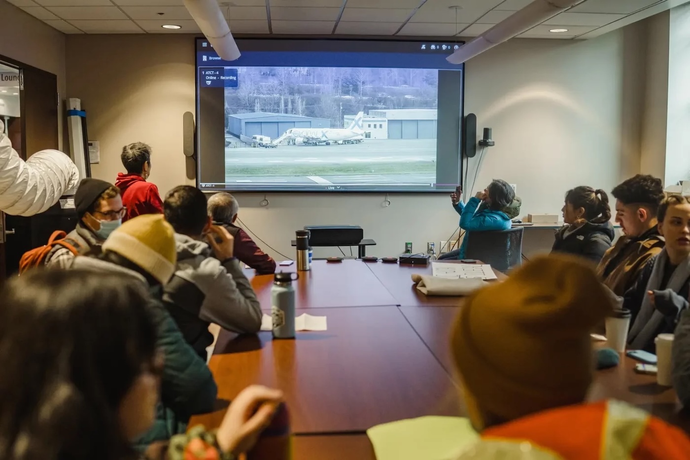 Иммиграционные адвокаты в Университете Вашингтона смотрят прямую трансляцию посадки на депортационный рейс в аэропорту Боинг-Филд